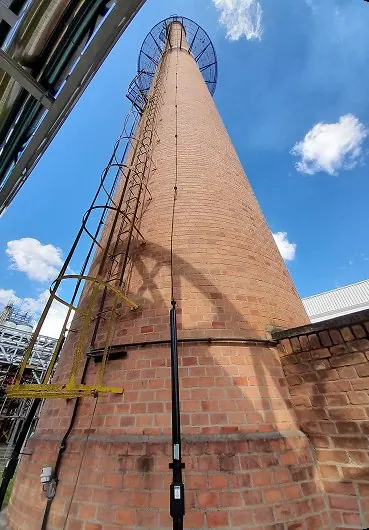 Condutor de descida instalado ao longo de chaminé industrial